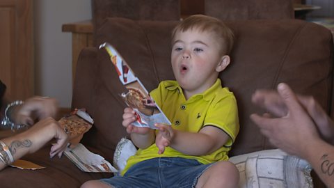 Boy holding a cereal box ripped up.