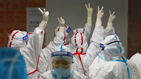 Getty Images Medical staff cheer themselves up before going into an ICU ward for Covid-19 patients in Wuhan, China (Credit: Getty Images)