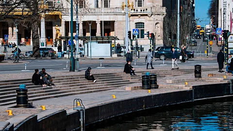 Getty Images People sit in the sun in Stockholm on March 26 during the Covid-19 pandemic (Credit: Getty Images)