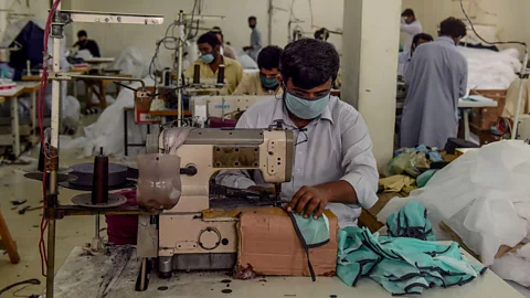 Asif Hassan/Getty Images As many places shut down in Pakistan, some workers have begun making protective masks for the public (Credit: Asif Hassan/Getty Images)