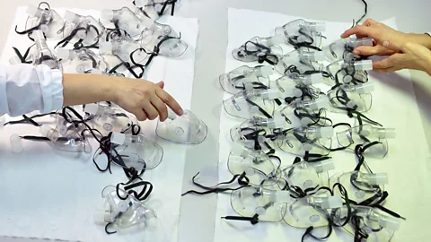 Getty Images Employees produce protective masks and parts for ventilators at a factory in Belarus; there has been a worldwide effort to scale up production (Credit: Getty Images)