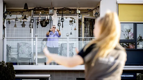 Koen Van Weel/Getty Images Balconies have again become platforms to connect and, in the case of these quarantined neighbours in the Netherlands, dance together (Credit: Koen Van Weel/Getty Images)