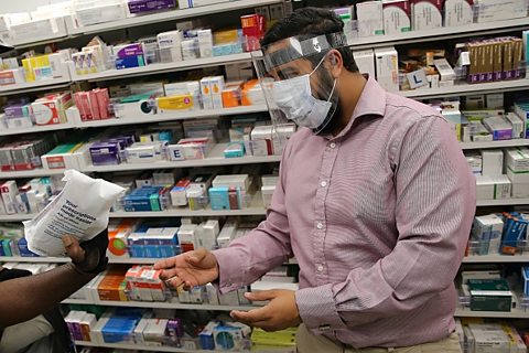 A pharmacist wears PPE