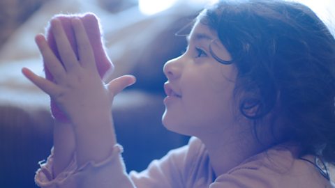 A little girl with a sock puppet.