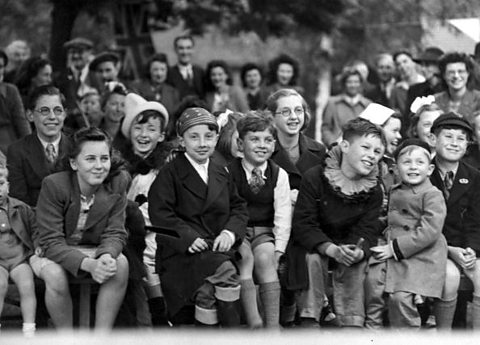 A group of seated children celebrate VE Day