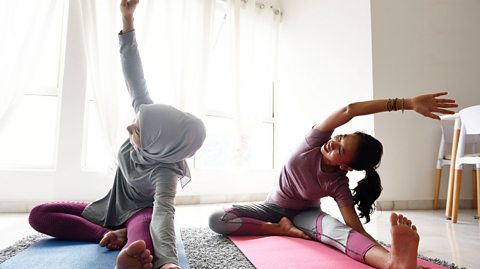 Two people doing yoga at home