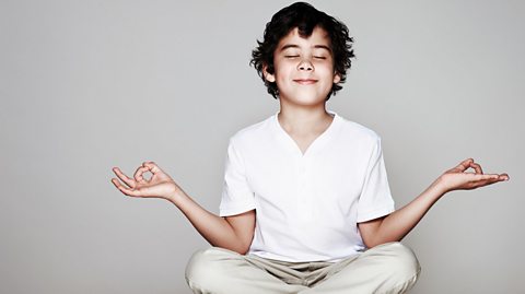 A young boy sat cross-legged meditating.