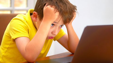 A child looking bored at a computer screen