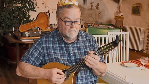 Lidia's grandad wearing the special crown and playing an instrument