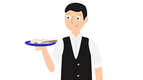 A waiter carries a plate of dumplings.