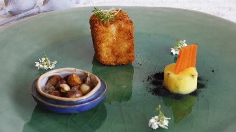 Bord För En The main course consists of a carrot-ginger puree, sweetcorn croquette and serpent root ash (Credit: Bord För En)