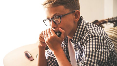 A boy plays the harmonica