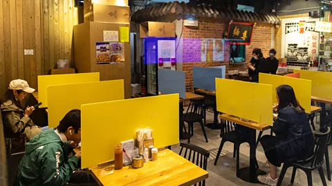Alamy Plastic barriers like these, at a restaurant in Hong Kong in April 2020, are based on ‘defensive design’ principles (Credit: Alamy)
