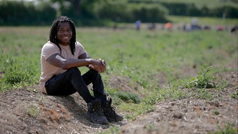 Ade Adepitan in a field which is being farmed