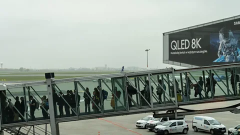 Alamy Passengers can spend several minutes queueing in crowded, poorly ventilated walkways as they board the plane