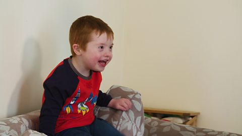 Ethan smiling and sat on sofa