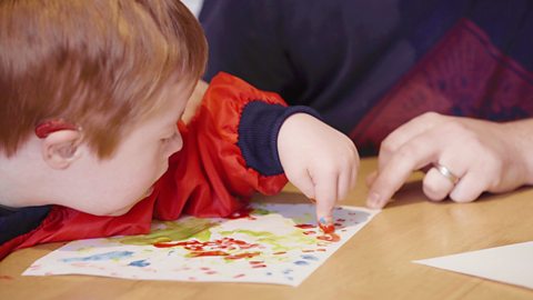 Close up of young boy finger painting