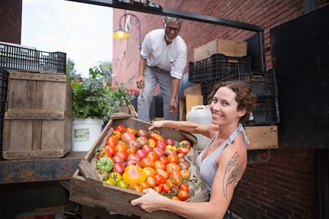 A food producer unloads a box of fresh fruit and veg from a lorry