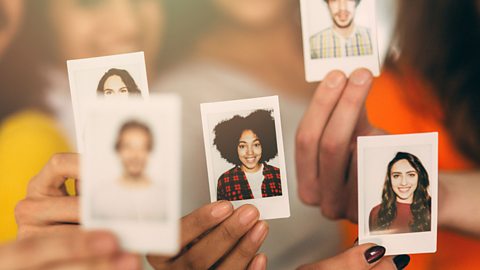 People holding up polaroid pictures of themselves.