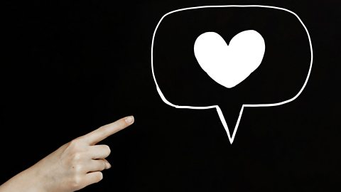 Finger pointing to a soicla media heart symbol. 