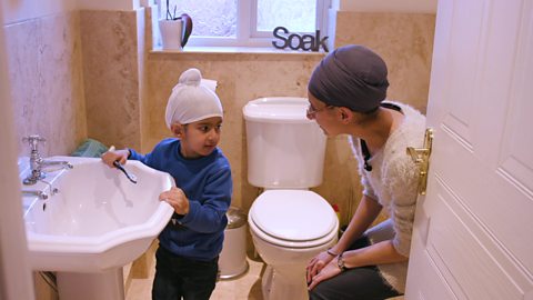 little boy brushing his teeth and getting ready for school with his mummy