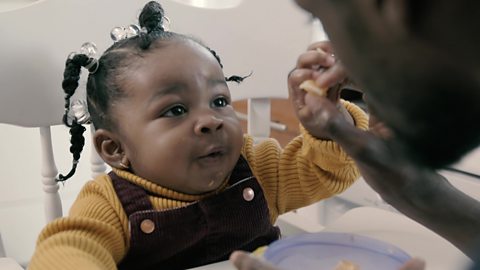 A little girl holding a satsuma segment.