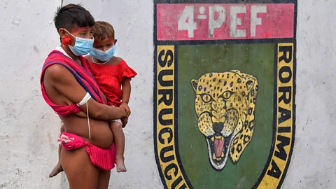 Getty Images A woman and baby from the Amazon’s Yanomami tribe wear face masks at a Covid-19 testing centre (Credit: Getty Images)