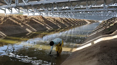 Getty Images The solar canals are suspended on a metal structure over the canal, with benefits for both water conservation below and cooling of the panels above (Credit: Getty Images)