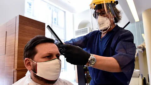 Reuters Many businesses that involve close with customers, such as hairdressers and barbers, are giving their staff face shields to wear (Credit: Reuters)