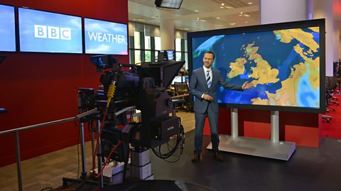 Weather presenter Nick Miller in front of the weather map in the weather studio