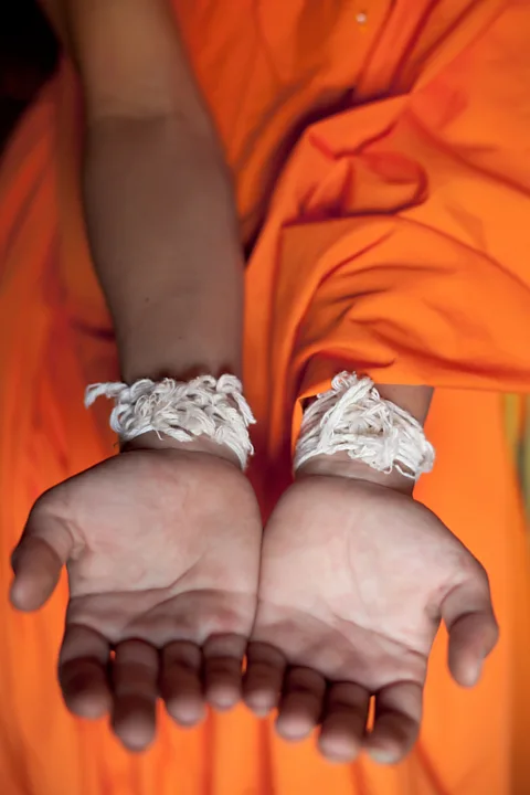 Steve Whyte/Alamy Strings tied around the wrist represent the connection between the person who’s having the life event and the community (Credit: Steve Whyte/Alamy)