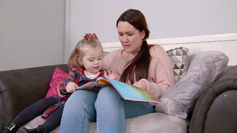 Mum and daughter looking at book together