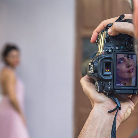 A man taking a photo of a model.