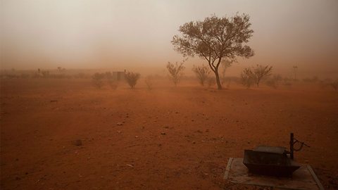 A landscape photograph showing a sandstorm in the Australian outback.