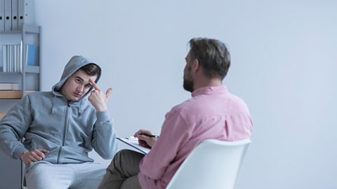 Teenage boy talking to a teacher