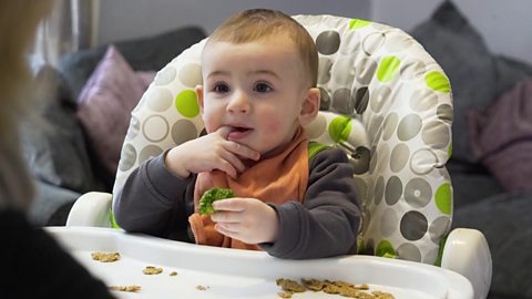 Baby trying broccoli for the first time.