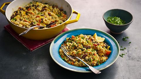 A cooking dish and bowl both filled with Original Flava's Caribbean rice and beans 