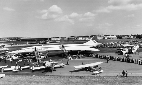 Concorde on display with a long line of people waiting to tour through the plane.