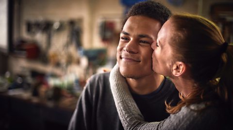 A mum kissing her child on the cheek