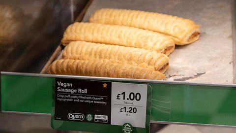 A tray of vegan sausage rolls in a shop