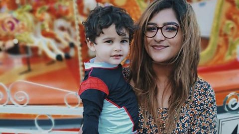 Yasmin and her son Remy by a carousel.