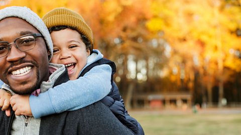 A little boy getting a piggy back from his dad