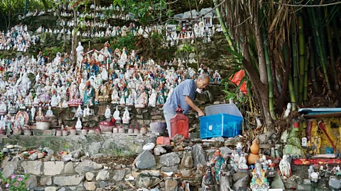 Matthew Keegan Wong cleans the statues and keeps glue in his pocket to piece back together chipped or broken deities (Credit: Matthew Keegan)