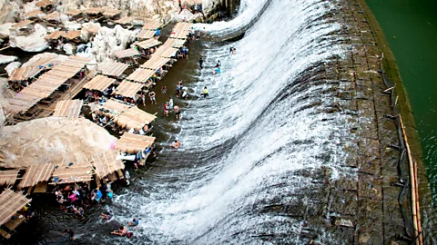 Noel Celis/Getty Images Even defunct dams can be useful, like this one near Manila in the Philippines, which supplies water to the thirsty on a hot day (Credit: Noel Celis/Getty Images)