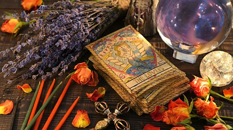 Tarot cards and a crystal ball surrounded by flowers