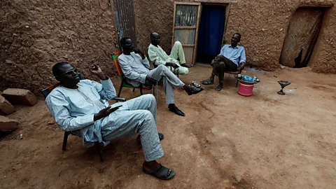 Reuters/Alamy Niger men choose to gather in the streets around a tea kettle rather than indoors (Credit: Reuters/Alamy)