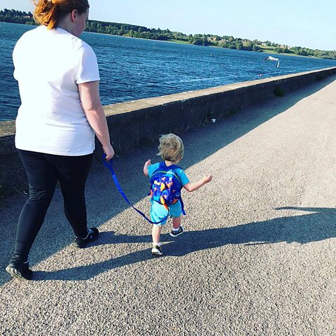 Shannon and Arthur going for a walk alongside a lake.