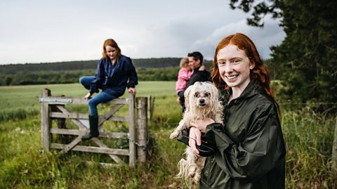 Teenage girl hikes with family and dog