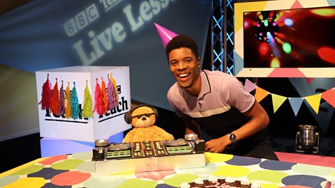 Rhys Stephenson wearing a party hat in the Live Lessons studio with a djing teddy bear.