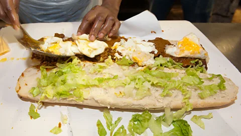 Eric Nathan/Alamy Packed with meat, chips, sauce, cheese, fried eggs and salad, the Gatsby is designed to be cut into four and shared (Credit: Eric Nathan/Alamy)